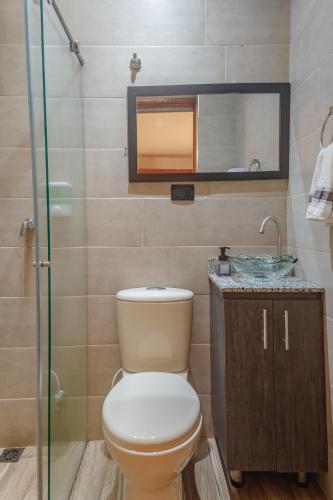 a bathroom with a toilet and a sink and a mirror at Hostal Machu Picchu Medellín in Medellín