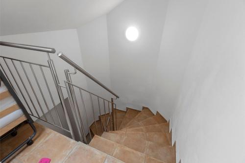a spiral staircase with a metal railing in a room at Bergblick Apartments in Radolfzell am Bodensee