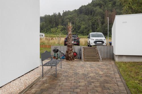 a parking lot with a bench and two trees at Bergblick Apartments in Radolfzell am Bodensee
