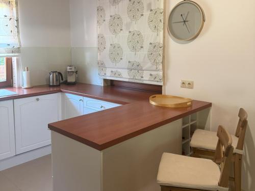 a kitchen with a counter and a clock on the wall at Bartoszy Zakątek in Bartoszylas