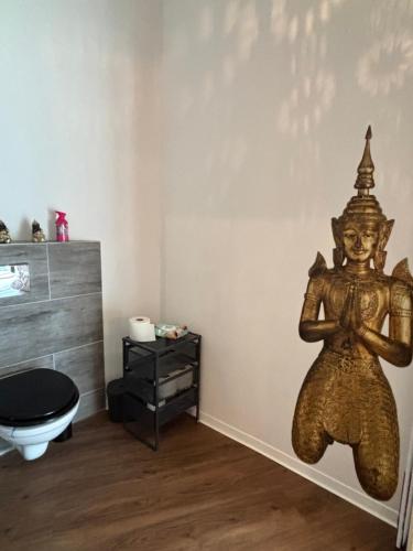 a bathroom with a statue of a god on the wall at Top Appartement in Bremerhaven