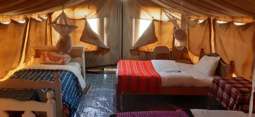 a bedroom with two beds in a tent at Esam Homestay in Sekenani