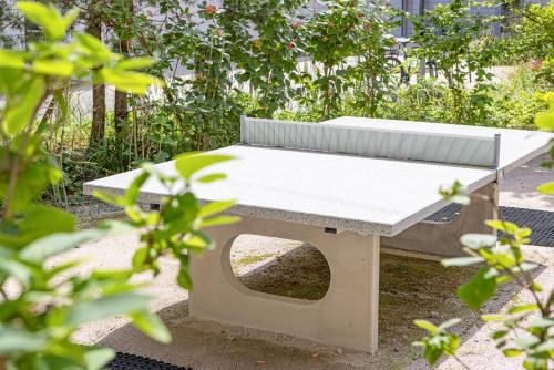 a white bench sitting in the middle of a garden at ARISER - Luzern Kriens Business Suites in Luzern