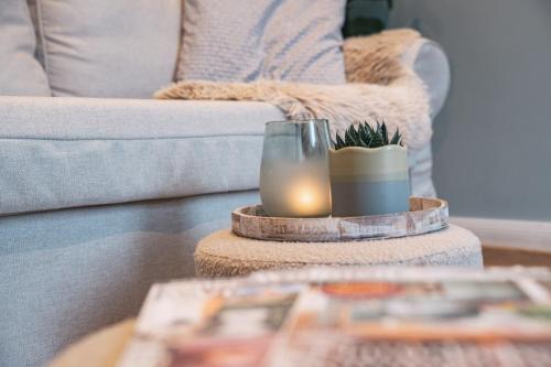 a living room with a couch and a candle on a table at Apart You I Oldtown River Retreat #1 in Bad Kreuznach