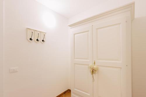 a white door with hangers on a white wall at Il Cuore delle Apuane in Antona