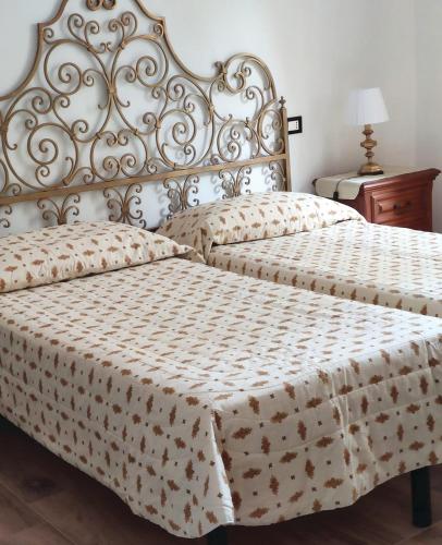 a bedroom with two beds and a table with a lamp at Domus Pisana in Pisa