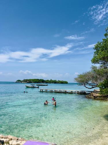a group of people in the water at a beach at Casa Rosario in Isla Grande