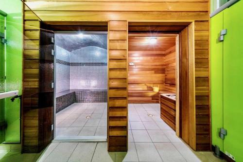 a bathroom with a shower with wooden walls and a glass door at Villa Bacchus in Saint-Christol