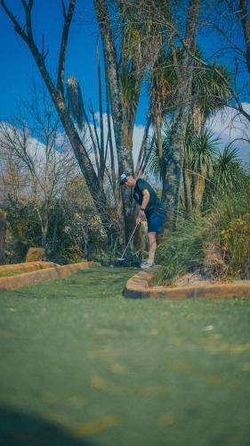 a man hitting a golf ball with a club at Gooderson Drakensberg Gardens Golf & Spa Resort in Drakensberg Garden