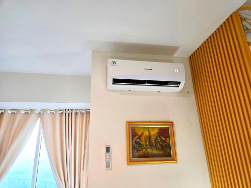 a room with a air conditioner on a wall at Apatermend grand kamala lagoon 1BR Cozy & Elegant by LuckyStay in Pulosirih