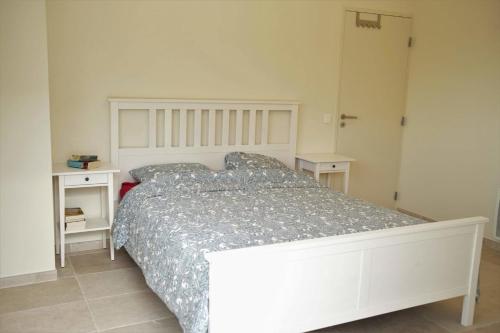 a bedroom with a white bed and two night stands at Maison des Vignes Swimming pool and charm in Lauris in Lauris
