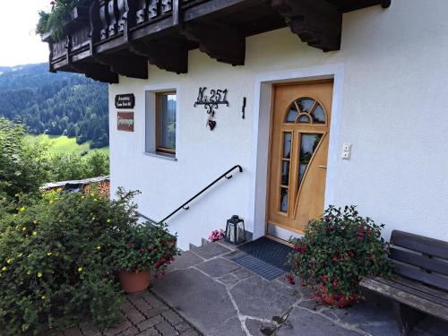a building with a wooden door and a bench at Haus Grünanger in Wildschönau