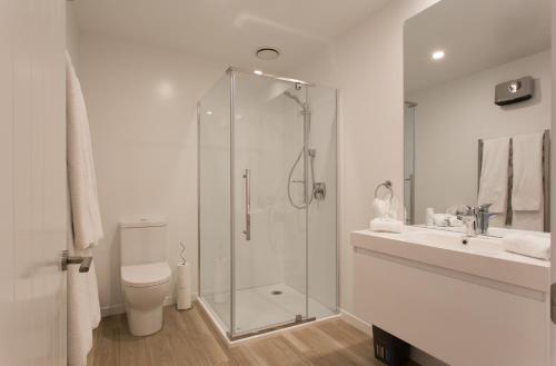 a bathroom with a shower and a toilet and a sink at Highland Views in Queenstown