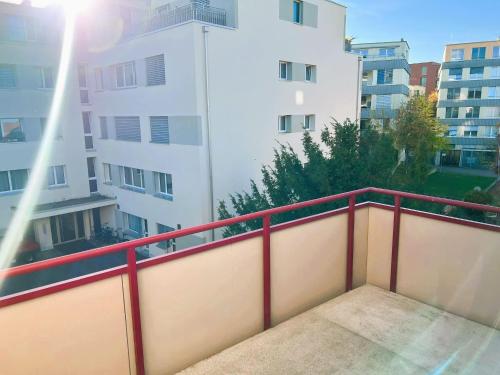 a balcony with a red railing in front of a building at Apartment with Balcony in Zurich, Kars - Self Checkin in Zürich