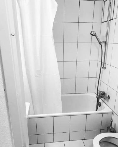 a bathroom with a shower and a toilet at Leon Studio Steps from Zurich HB Station in Zürich