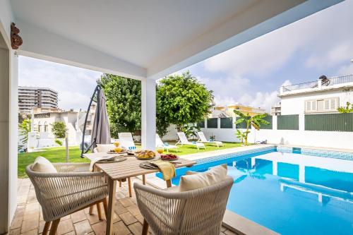 un patio con tavolo e sedie accanto alla piscina di Urban Bliss Boutique Guesthouse a Faro
