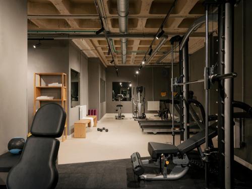 une salle de sport avec deux tapis de course et un tapis roulant dans l'établissement Edgar Suites Montrouge, à Montrouge