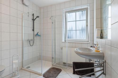 a white bathroom with a shower and a sink at Casa Rolando in Nördlingen