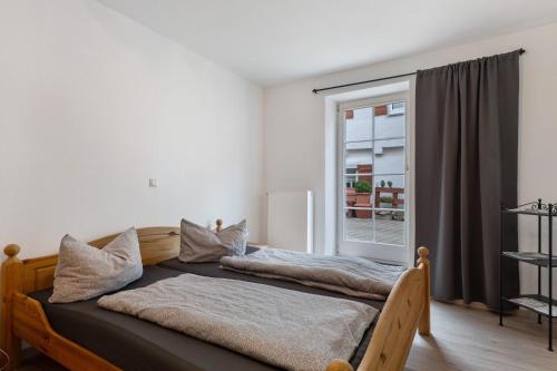 two beds in a room with a window at Casa Rolando in Nördlingen