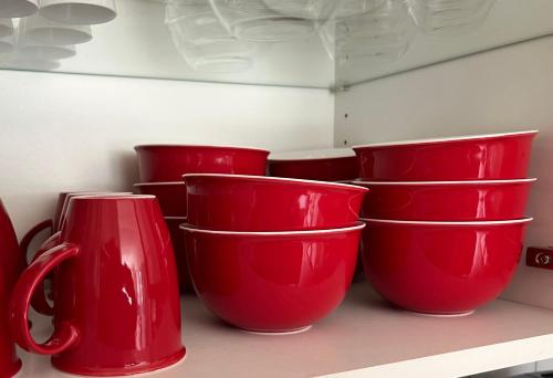 a group of red cups sitting on a shelf at Ferienwohnung Kronegarten in Gmunden