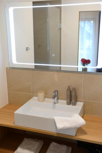 a bathroom sink with a large mirror above it at Landgasthof Sagenhaft in Klagenfurt