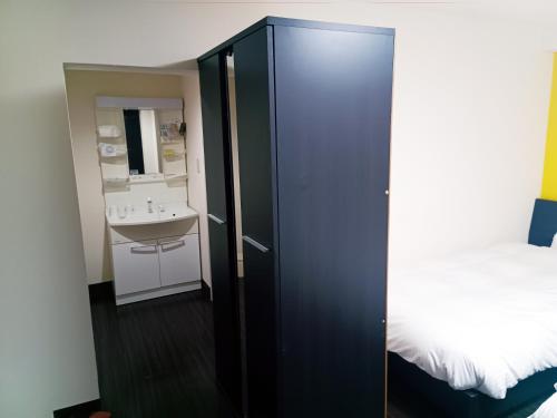 a bedroom with a bed and a cabinet with a sink at Ace Inn Asakusa in Tokyo