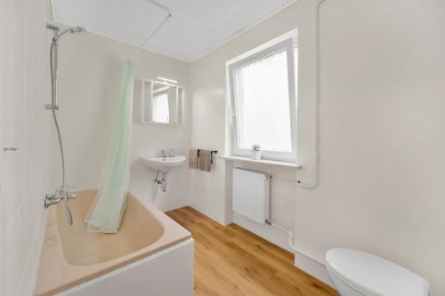 a white bathroom with a tub and a sink at Zentrale Monteurunterkunft in Celle
