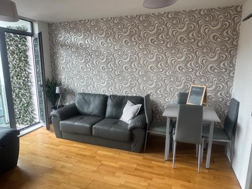 een woonkamer met een bank en een tafel bij 2 Bedroom Apartment - Henry St Central Liverpool in Liverpool