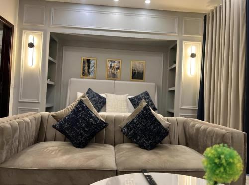 a living room with a couch with pillows on it at Elysium Luxe Stays Facing Cenaturus Mall Islamabad in Islamabad