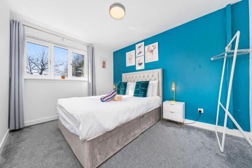 una camera da letto blu con un letto e una parete blu di Quirky, Family Home in Glasgow a Cardonald