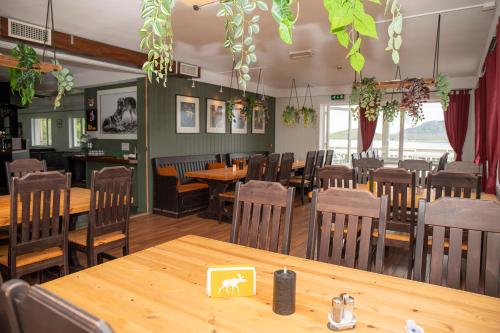 a dining room with wooden tables and chairs at Ulvsvåg Gjestgiveri og Fjordcamping AS in Ulvsvåg