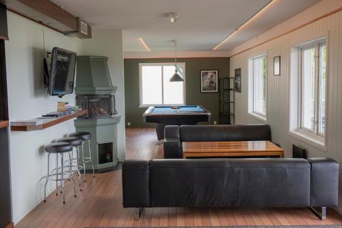 a living room with a couch and a pool table at Ulvsvåg Gjestgiveri og Fjordcamping AS in Ulvsvåg