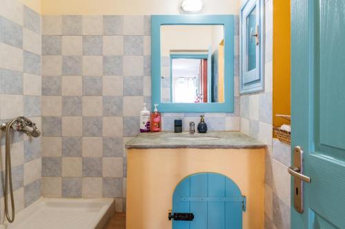 a bathroom with a sink and a blue door at La Casa Tinos 22 in Agios Ioannis Tinos