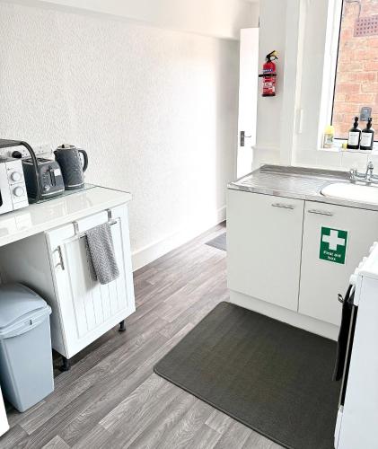 a bathroom with white cabinets and a sink at Richmond Nights