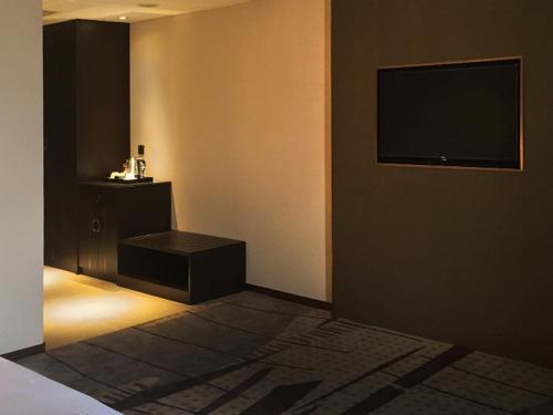 a room with a television on a wall at Geno Hotel Shah Alam in Shah Alam