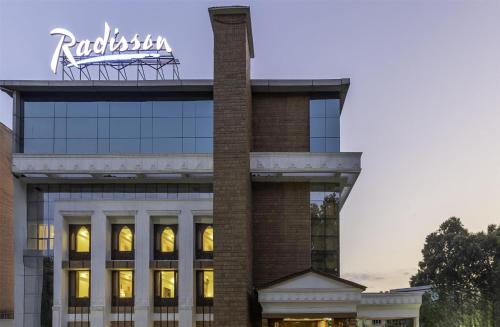 a building with a sign on top of it at Radisson Srinagar in Srinagar