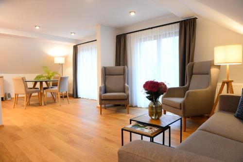 a living room with a couch and chairs and a table at Landgasthof Sagenhaft in Klagenfurt