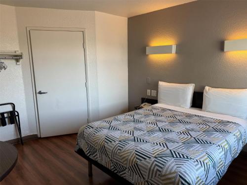 a hotel room with a bed and a door at Studio 6 Suites Las Vegas, NV - Tropicana in Las Vegas