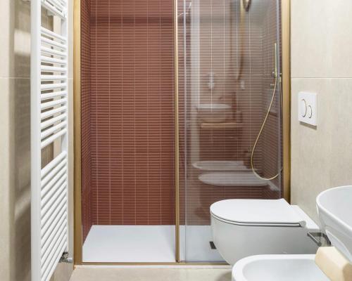 a bathroom with a shower with a toilet and a sink at QN Apartments in Venice