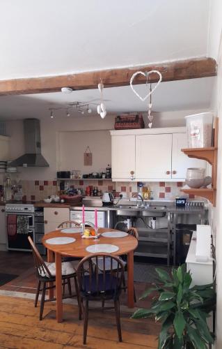 a kitchen with a wooden table and chairs in it at Hygge Somerset in Street