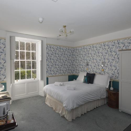 a bedroom with a bed with blue and white wallpaper at Rydal Lodge in Rydal