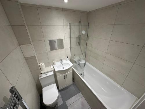 a bathroom with a toilet and a sink and a tub at London Luton Airport Luxury Midland Apartments - GATED PARKING - Balcony - Sleeps 4 in Luton