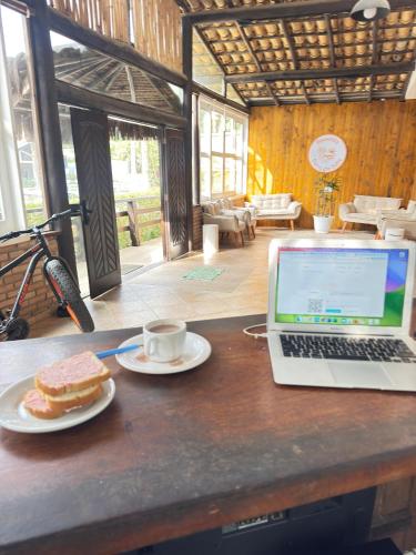 a laptop computer sitting on a table with a plate of food at Pousada Barra do Sahy in Barra do Sahy