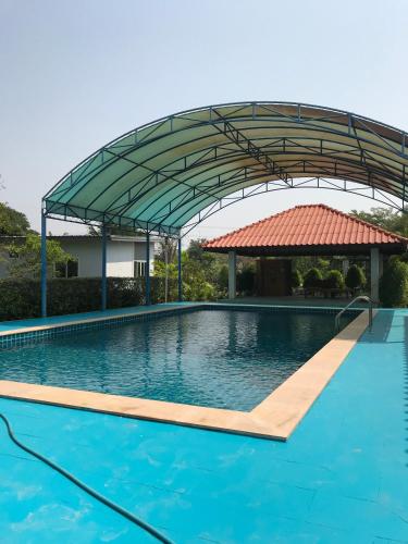 a large swimming pool with a metal canopy over it at Sripiamsuk Resort Bangkok in Pathum Thani