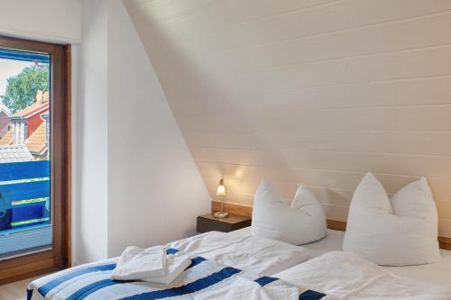 a bedroom with a bed with white pillows and a window at Haus Lotte in Wittmund