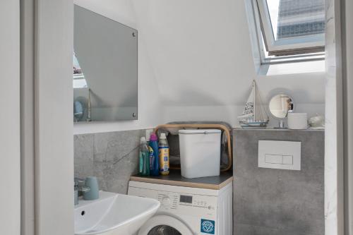 a bathroom with a sink and a washing machine at Haus Lotte in Wittmund
