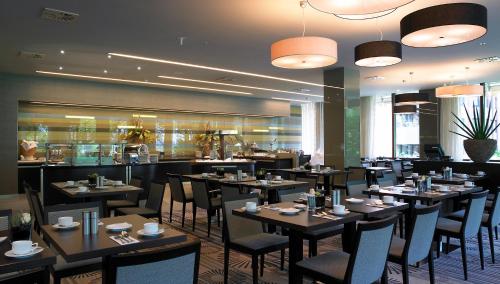 a dining room with tables and chairs in a restaurant at Crowne Plaza Düsseldorf - Neuss by IHG in Neuss