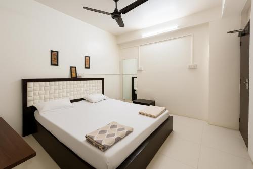 a white bedroom with a large bed with a ceiling at Homestay Ac Dormitory in New Delhi