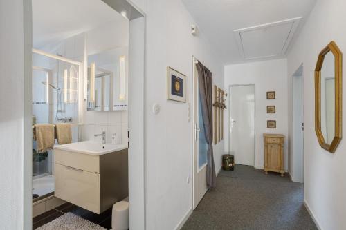 a white bathroom with a sink and a mirror at Ferienwohnung Riedel in Amecke