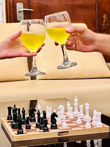 two people drinking wine and playing a game of chess at AHA Luxury Villa - 3BR Retreat in Central Udaipur in Udaipur